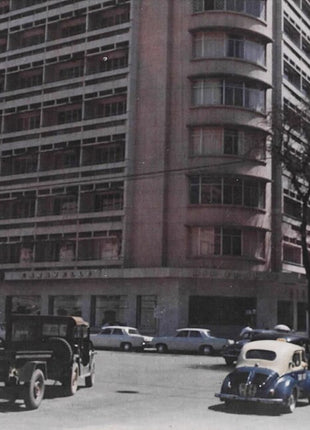 Historic photograph of the Caravelle Hotel in downtown Saigon (now Ho Chi Minh City, Vietnam), showing the modern high-rise hotel building and vintage automobiles on a busy city street. The Caravelle Hotel was a prominent landmark during the Vietnam War era. This image is in the public domain in the United States.