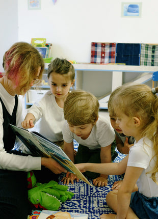 Teacher reading a children’s book to a small group of kids in a classroom, illustrating middle grade reading, literacy, and book discussion inspired by The One and Only Ivan