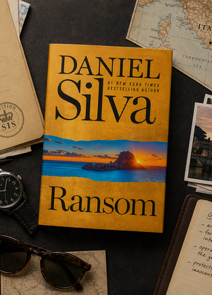 Flat lay intelligence briefing scene featuring Dan Silva's thriller Ransom surrounded by a passport, map, sunglasses, notebook, pen, and coffee, evoking espionage, international intrigue, and covert operations in a luxury travel setting.